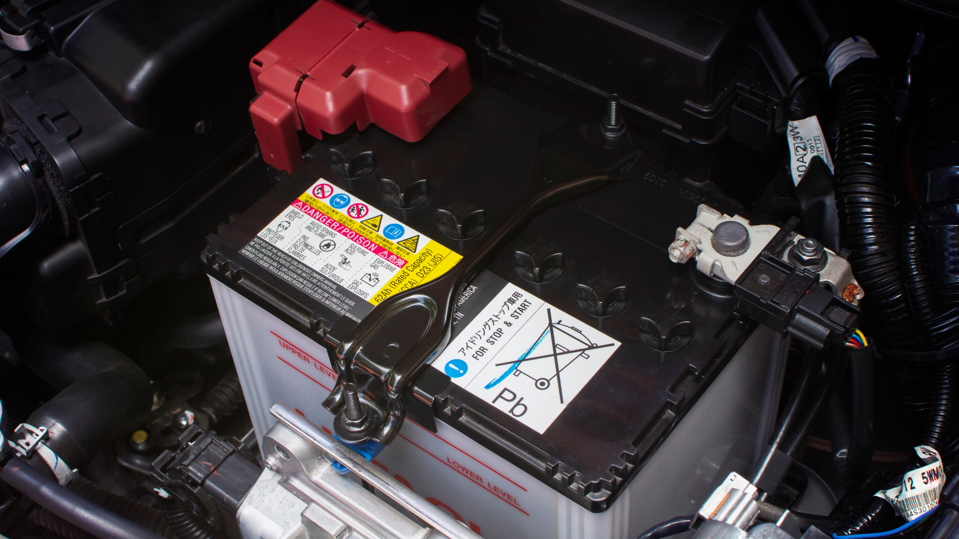 Car battery seated in the engine bay with terminal cover