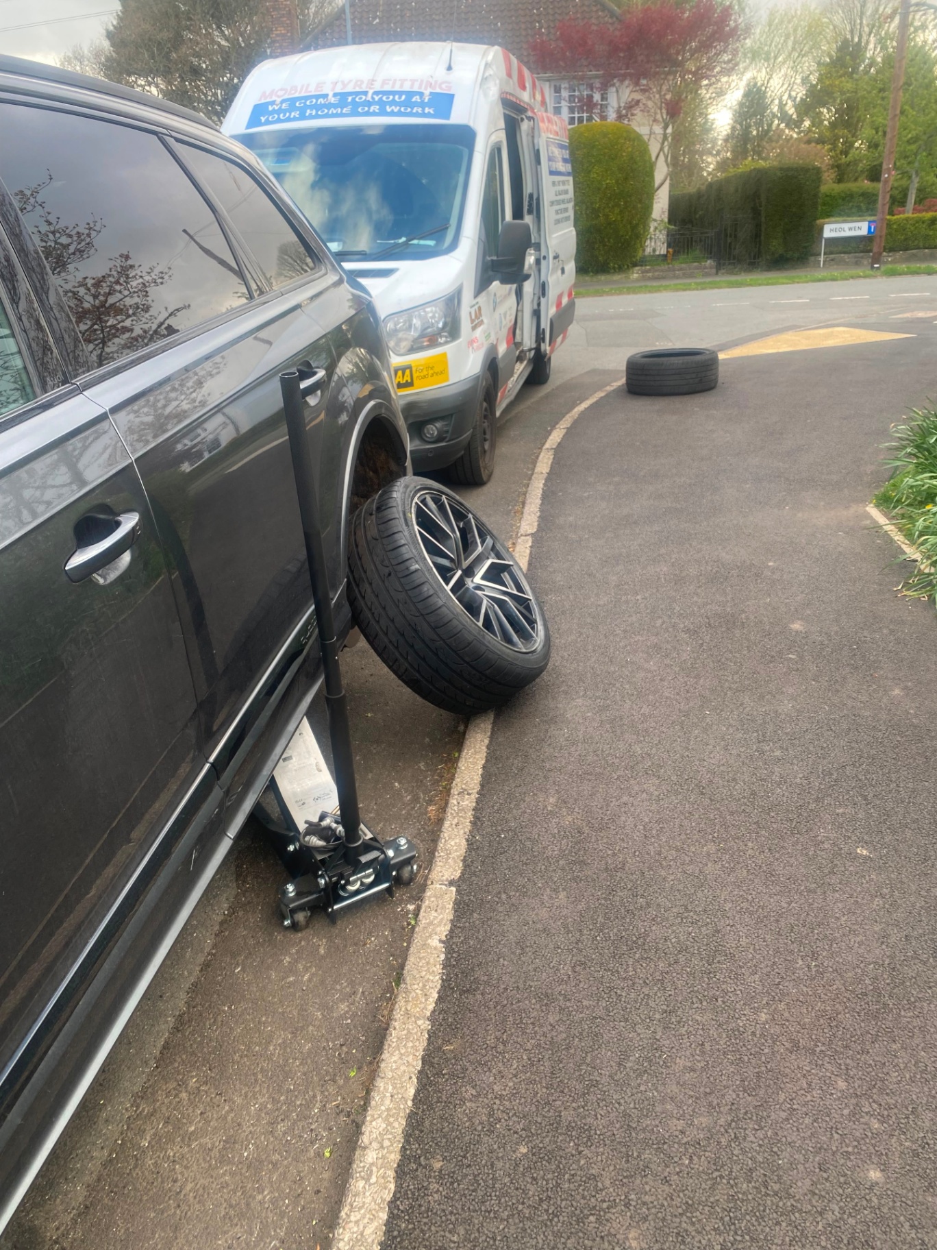 Mobile tyre fitting on an SUV — replacement wheel beside the vehicle