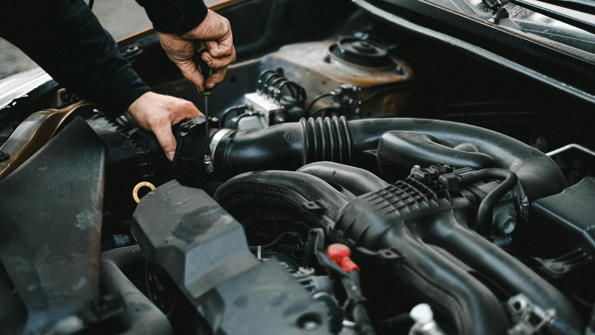 Mechanic servicing a car engine bay